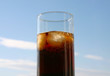 cola on ice, blue sky in background