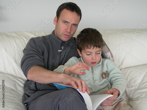 Photo: père lisant un livre à son fils père lisant un livre à son fils
