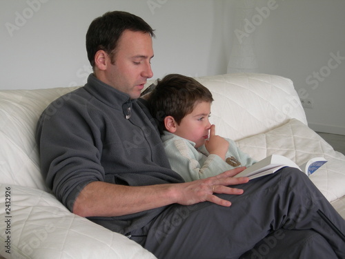 Photo: père lisant un livre à son fils père lisant un livre à son fils