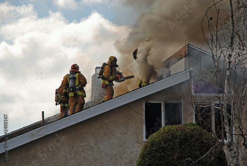 Photo: fire fighters on a roof fire fighters on a roof