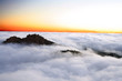 amanecer en monte aislado entre mar de nubes