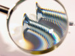 two screws under a magnifier.checking the quality.