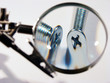 two screws under a magnifier.checking the quality.