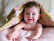 Foto: happy baby peeking out from under blanket happy baby peeking out from under blanket