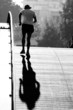middle aged runner crossing bridge