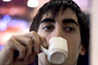 jeune homme boit son café dans un bar