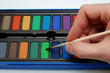 watercolors and hand holding a brush