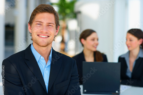 portrait of a young man in front of a workgroup