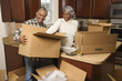 Photo: middle-aged couple unpacking boxes. middle-aged couple unpacking boxes.