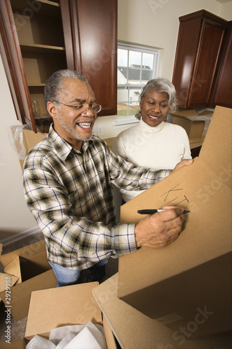 Photo: middle-aged couple with moving boxes. middle-aged couple with moving boxes.