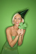 young caucasian woman wearing party hat and holding shamrock.