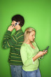 caucasian teen boy and girl on cellphones.