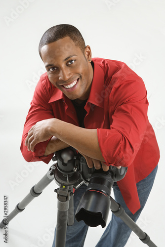 young male adult photographer posing in studio.