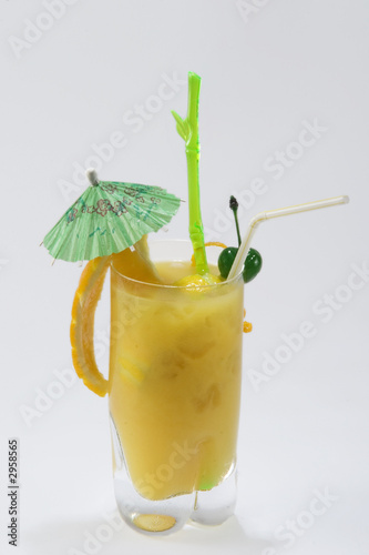 Photo: yellow drink with green umbrella on white backgrou yellow drink with green umbrella on white backgrou