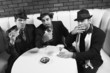 three retro businessmen sitting at table with cocktails.