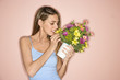 Photo: mid-adult female smelling pot of flowers. mid-adult female smelling pot of flowers.