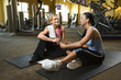 adult female with personal trainer at gym.
