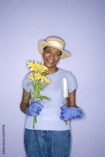 Photo: woman with hand shovel and flowers. woman with hand shovel and flowers.