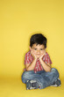 Boy sitting with head on hands.