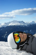 Boy snowboarder lying on mountain.