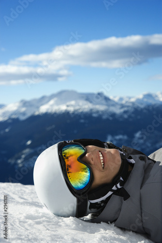 Foto: Boy snowboarder lying on mountain. Boy snowboarder lying on mountain.