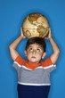Foto: Male boy holding globe on head. Male boy holding globe on head.