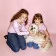 Girls holding Cocker Spaniel dog.