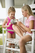 Older girl showing conch shell to younger girl.