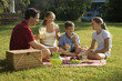Photo: Family having picnic in park. Family having picnic in park.