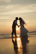 Photo: Bride and groom kissing on beach. Bride and groom kissing on beach.