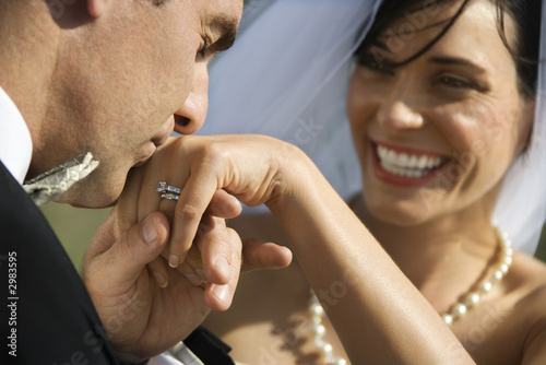 Photo: Groom kissing hand of smiling bride. Groom kissing hand of smiling bride.