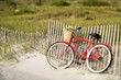 Foto: Bike leaning against fence at beach. Bike leaning against fence at beach.