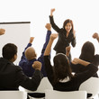 Photo: businesswoman leading presentation while audience cheers. businesswoman leading presentation while audience cheers.