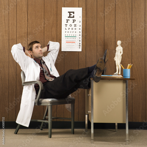 male doctor with feet on desk.