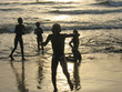 young african childrens playing at the sunset on a tropical beac