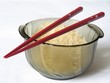 bowl full of uncooked rice with red chopsticks