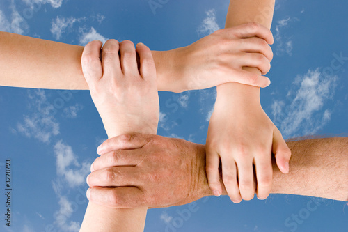 Photo: four hands joined together four hands joined together
