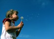 girl blowing off a dandelion