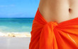 woman in orange skirt on a beach.