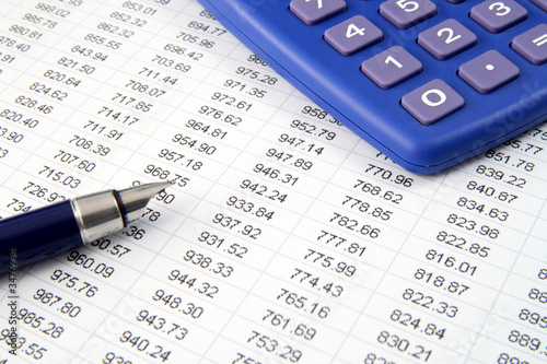 studying financial numbers on a printed spreadshee studying financial numbers on a printed spreadshee