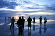 group watching sunset over wet salt flats group watching sunset over wet salt flats