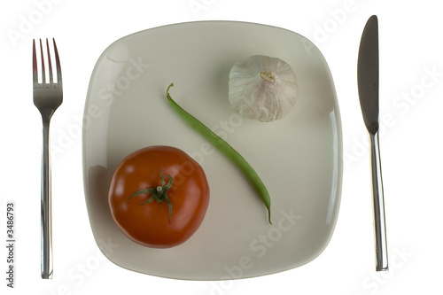 Photo: plate with tomato, green bean and garlic. isolated plate with tomato, green bean and garlic. isolated
