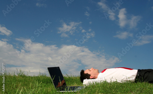 Foto: man lying on the grass with laptop man lying on the grass with laptop