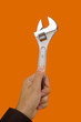 a hand holding a Wrench tool with a color background