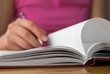 Young female opens notebook and planning her schedule.