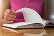 Young female opens notebook and planning her schedule.