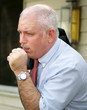 A mature businessman with a severe coughing fit. A mature businessman with a severe coughing fit.