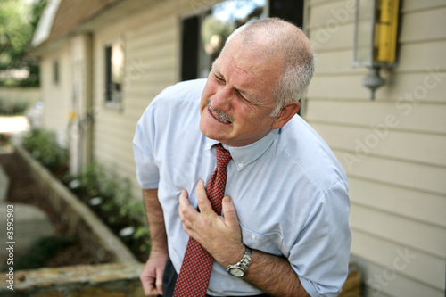Photo: mature businessman clutching his chest mature businessman clutching his chest