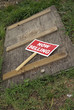 abandoned old wooden door with a discarded "now selling" sign