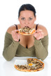 Prerry girl sitting by the table and eating a slice of pizza